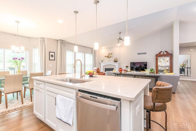 9302 W Meadow Dr, West Chester, OH 45069 - kitchen featuring stainless steel dishwasher, a fireplace, a ceiling fan, and light wood finished floors