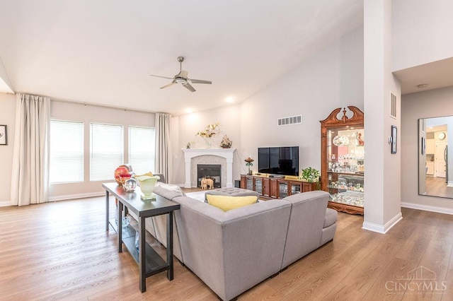 9302 W Meadow Dr, West Chester, OH 45069 - living area featuring ceiling fan, wood finished floors, a glass covered fireplace, and high vaulted ceiling