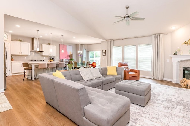 9302 W Meadow Dr, West Chester, OH 45069 - living area with a ceiling fan, vaulted ceiling, light wood finished floors, recessed lighting, and a glass covered fireplace