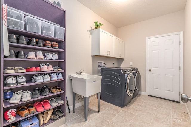 9302 W Meadow Dr, West Chester, OH 45069 - laundry room featuring washing machine and dryer, cabinet space, and light tile patterned floors