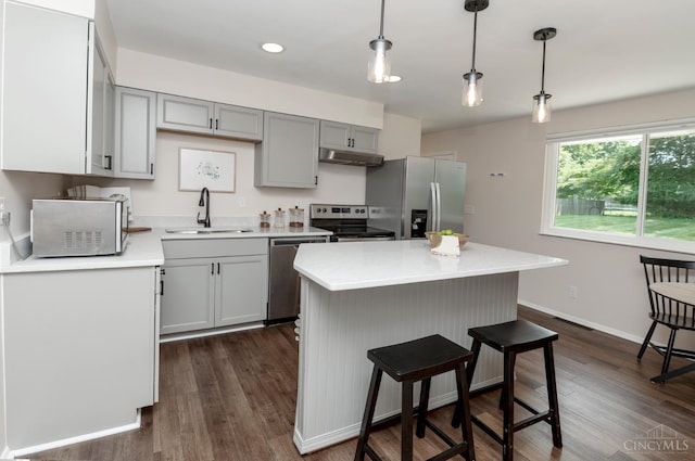 601 Comet Dr, Union Twp, OH 45244 - kitchen with appliances with stainless steel finishes, under cabinet range hood, light countertops, dark wood-type flooring, and a breakfast bar area