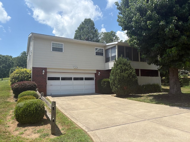 44 Strathmore Blvd, Athens, OH 45701 - view of front of property featuring brick siding, a garage, driveway, and a sunroom