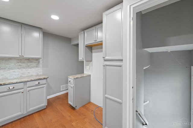 5611 Glengate Ln, Cincinnati, OH 45212 - kitchen featuring decorative backsplash, light wood-type flooring, recessed lighting, light stone countertops, and white cabinetry
