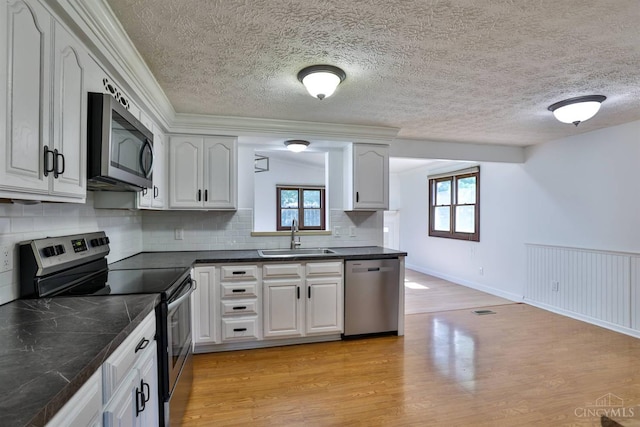 115 Treeline Ct, Harrison, OH 45030 - kitchen featuring stainless steel appliances, dark countertops, plenty of natural light, light wood finished floors, and a textured ceiling