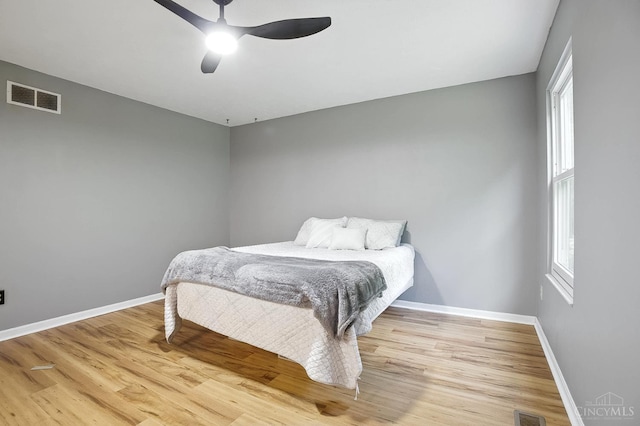4653 Cardinal Dr, Union Twp, OH 45244 - bedroom with light wood-style flooring, multiple windows, and a ceiling fan