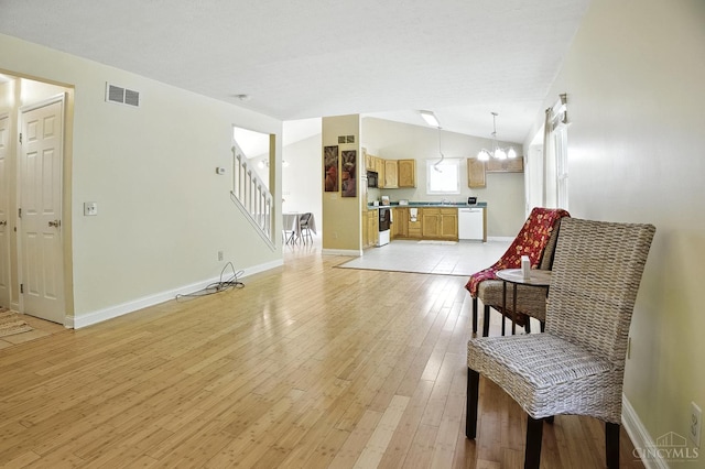 4653 Cardinal Dr, Union Twp, OH 45244 - living area with light wood-style flooring, vaulted ceiling, stairway, and a chandelier