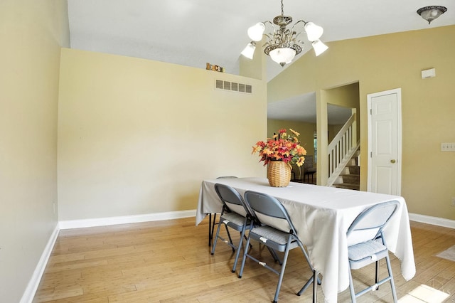 4653 Cardinal Dr, Union Twp, OH 45244 - dining area featuring a chandelier, wood finished floors, lofted ceiling, and stairs
