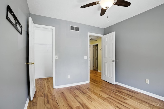 4653 Cardinal Dr, Union Twp, OH 45244 - unfurnished bedroom with light wood-type flooring, a walk in closet, and a ceiling fan