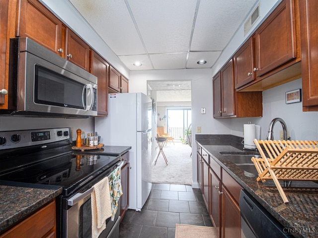 355 Grand Ave Unit 302, Cincinnati, OH 45205 - kitchen featuring stainless steel appliances, recessed lighting, dark colored carpet, dark stone countertops, and dark tile patterned flooring