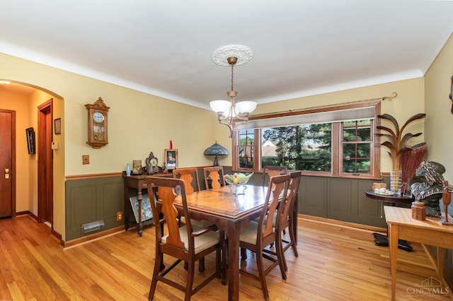 1107 Covedale Ave, Cincinnati, OH 45238 - dining area with a chandelier, arched walkways, light wood finished floors, and wainscoting