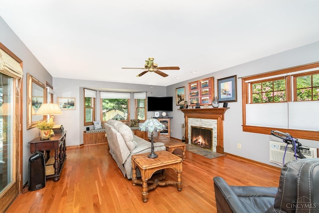 1107 Covedale Ave, Cincinnati, OH 45238 - living area featuring a wall unit AC, a fireplace, ceiling fan, and light wood-type flooring