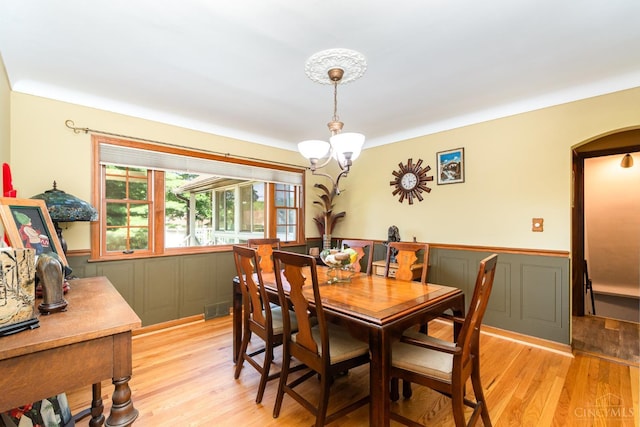 1107 Covedale Ave, Cincinnati, OH 45238 - dining space with a wainscoted wall, light wood-style flooring, a chandelier, arched walkways, and a decorative wall