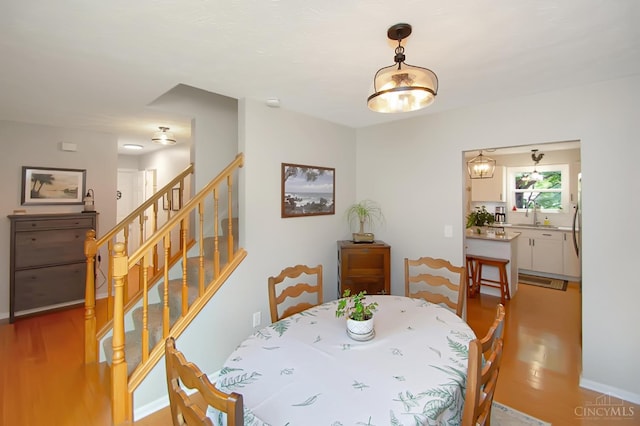 6711 Bayberry Ct, Hamilton Twp, OH 45039 - dining space featuring light wood-style flooring and stairway
