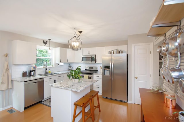 6711 Bayberry Ct, Hamilton Twp, OH 45039 - kitchen with stainless steel appliances, backsplash, white cabinets, and light wood-style flooring