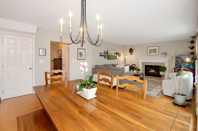 6711 Bayberry Ct, Hamilton Twp, OH 45039 - dining room with a chandelier, a warm lit fireplace, and wood finished floors