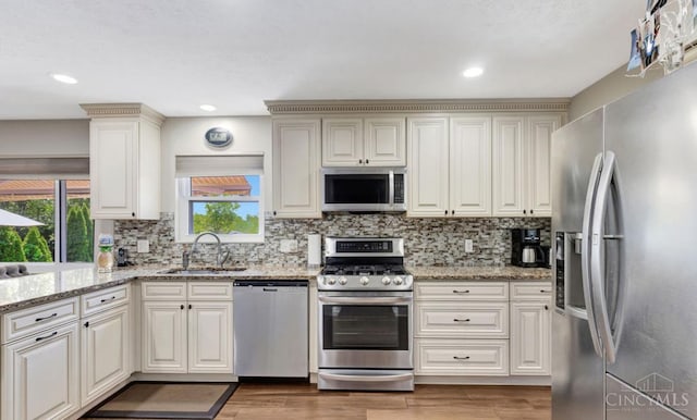5817 Countryview Ter, Delhi Twp, OH 45233 - kitchen featuring stainless steel appliances, light wood-style floors, decorative backsplash, light stone countertops, and recessed lighting
