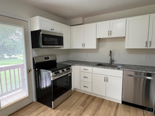 2035 Miles Rd, Cincinnati, OH 45231 - kitchen with stainless steel appliances, healthy amount of natural light, white cabinetry, and light wood-style floors