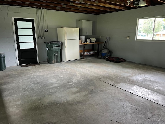 2035 Miles Rd, Cincinnati, OH 45231 - garage featuring freestanding refrigerator, a garage door opener, and concrete block wall
