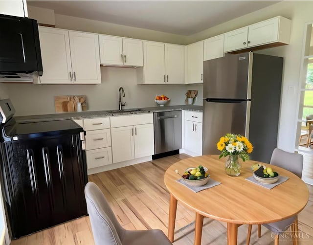 2035 Miles Rd, Cincinnati, OH 45231 - kitchen with appliances with stainless steel finishes, light wood finished floors, and white cabinetry