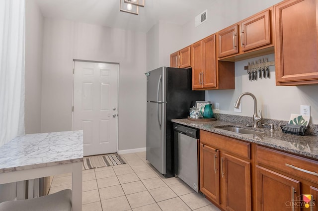 2711 Price Ave, Cincinnati, OH 45204 - kitchen featuring dishwasher, light tile patterned floors, dark stone counters, and brown cabinets