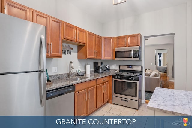2711 Price Ave, Cincinnati, OH 45204 - kitchen with stainless steel appliances, light tile patterned floors, light stone counters, and brown cabinets