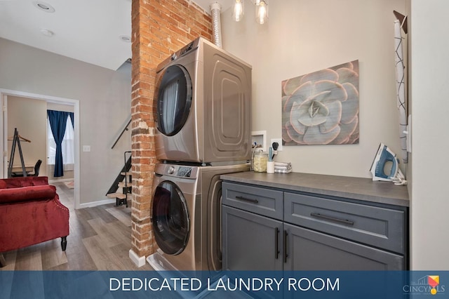 2711 Price Ave, Cincinnati, OH 45204 - washroom with cabinet space, stacked washing machine and dryer, and wood finished floors