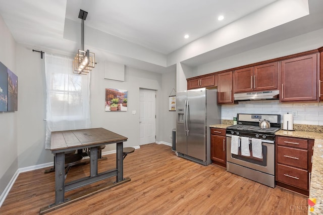2711 Price Ave, Cincinnati, OH 45204 - kitchen with appliances with stainless steel finishes, under cabinet range hood, light wood-style flooring, decorative backsplash, and light stone counters