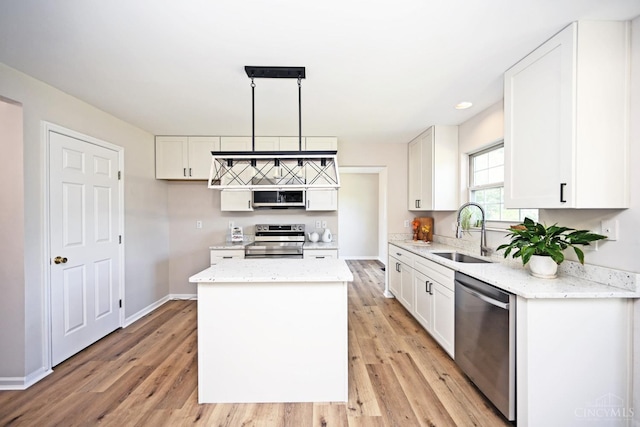 1055 Valley Wood Dr, Union Twp, OH 45103 - kitchen with stainless steel appliances, a kitchen island, light wood-type flooring, white cabinets, and light stone countertops