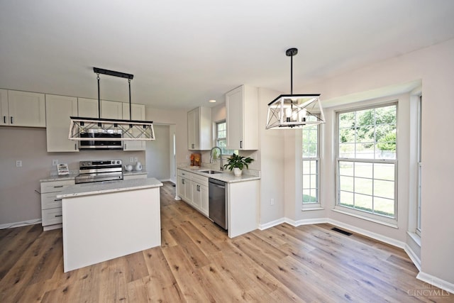1055 Valley Wood Dr, Union Twp, OH 45103 - kitchen with appliances with stainless steel finishes, a chandelier, white cabinets, and light wood-style flooring