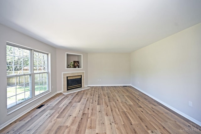 1055 Valley Wood Dr, Union Twp, OH 45103 - unfurnished living room featuring light wood-type flooring, plenty of natural light, and a tile fireplace