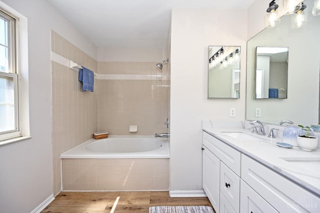 1055 Valley Wood Dr, Union Twp, OH 45103 - full bathroom with wood finished floors, plenty of natural light, double vanity, and tiled shower / bath combo