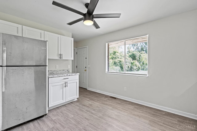 2016 Mistyhill Dr, Springfield Twp, OH 45240 - kitchen with freestanding refrigerator, white cabinets, a ceiling fan, light wood-style flooring, and light stone counters