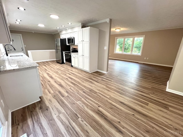 176 Lakeview Dr, Monroe, OH 45044 - kitchen featuring appliances with stainless steel finishes, open floor plan, ornamental molding, light wood-style flooring, and white cabinets