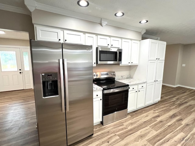 176 Lakeview Dr, Monroe, OH 45044 - kitchen with appliances with stainless steel finishes, crown molding, white cabinetry, light wood-style floors, and light stone countertops