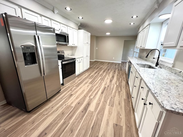 176 Lakeview Dr, Monroe, OH 45044 - kitchen featuring stainless steel appliances, light wood-style floors, white cabinetry, recessed lighting, and light stone countertops