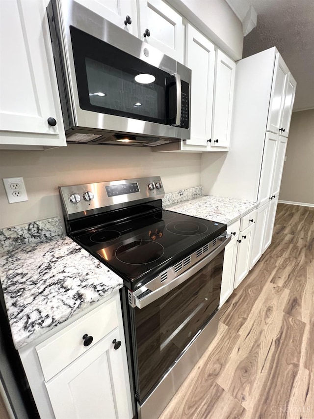 176 Lakeview Dr, Monroe, OH 45044 - kitchen with stainless steel appliances, light wood-type flooring, white cabinetry, and light stone countertops
