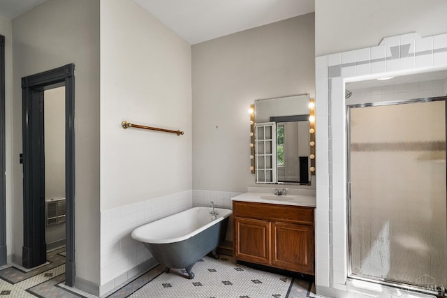 2153 Sinton Ave, Cincinnati, OH 45206 - full bath with a shower stall, vanity, a soaking tub, tile walls, and tile patterned floors