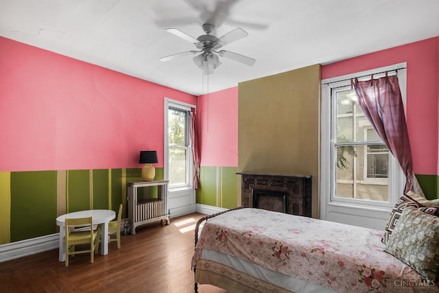 2153 Sinton Ave, Cincinnati, OH 45206 - bedroom with wood finished floors, a wainscoted wall, a fireplace, and ceiling fan