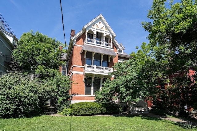 2153 Sinton Ave, Cincinnati, OH 45206 - back of property featuring brick siding, a chimney, a balcony, and a yard
