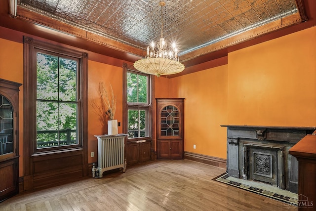 2153 Sinton Ave, Cincinnati, OH 45206 - unfurnished living room with an ornate ceiling, a chandelier, a raised ceiling, radiator heating unit, and wood finished floors