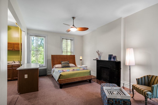 2153 Sinton Ave, Cincinnati, OH 45206 - bedroom with radiator heating unit, dark carpet, a fireplace, and a ceiling fan