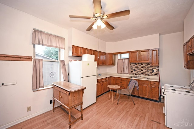 1319 Jefferson Ave, Reading, OH 45215 - kitchen featuring white appliances, brown cabinets, light wood-style flooring, a ceiling fan, and tasteful backsplash