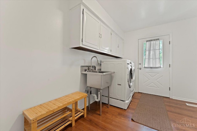 5577 Dove Ln, West Chester, OH 45069 - laundry area featuring cabinet space, washing machine and clothes dryer, and wood finished floors