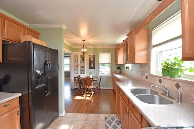 1008 Garden Ave, Middletown, OH 45044 - kitchen with black fridge, light countertops, light tile patterned floors, crown molding, and decorative light fixtures