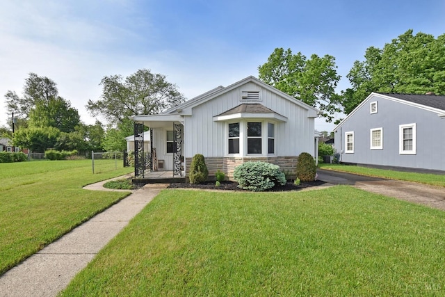 1008 Garden Ave, Middletown, OH 45044 - bungalow-style house featuring a front lawn, stone siding, covered porch, and board and batten siding