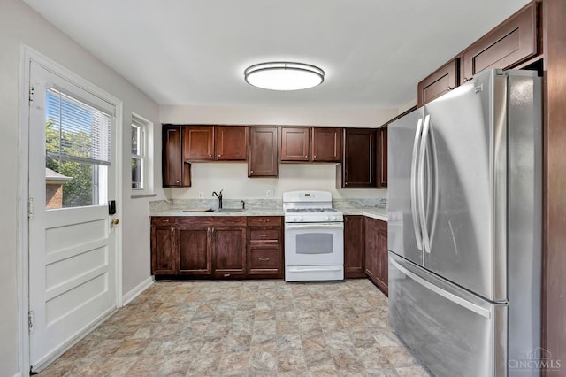 7866 Stillwell Rd, Cincinnati, OH 45237 - kitchen with freestanding refrigerator, white gas range oven, light countertops, stone finish floors, and dark brown cabinetry