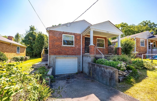 7866 Stillwell Rd, Cincinnati, OH 45237 - view of front of home with an attached garage, brick siding, driveway, and a porch