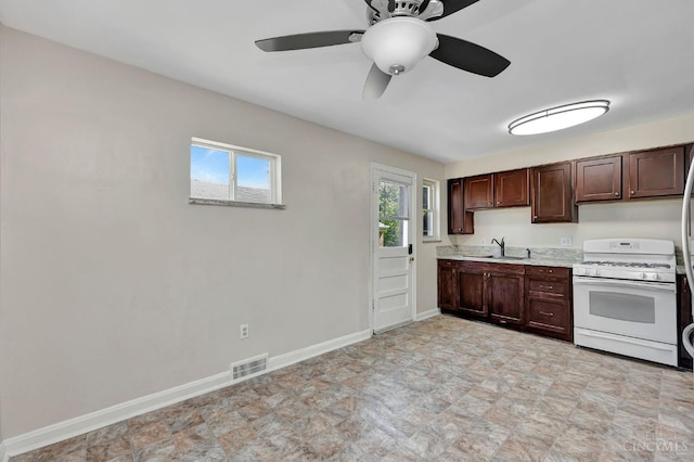 7866 Stillwell Rd, Cincinnati, OH 45237 - kitchen with white gas range oven, light countertops, a ceiling fan, and dark brown cabinetry