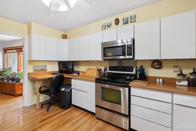 600 Kathryn Dr, Wilmington, OH 45177 - kitchen with stainless steel appliances, white cabinets, light wood finished floors, a ceiling fan, and built in desk