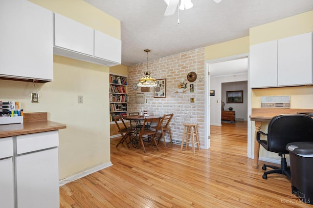 600 Kathryn Dr, Wilmington, OH 45177 - kitchen featuring white cabinets, a desk, light wood-style floors, ceiling fan, and decorative light fixtures